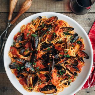 mussels with pasta and tomato sauce in a white serving bowl {sponsored}