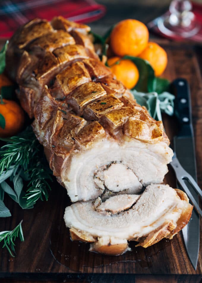 porchetta roast with a slice cut on a wood board