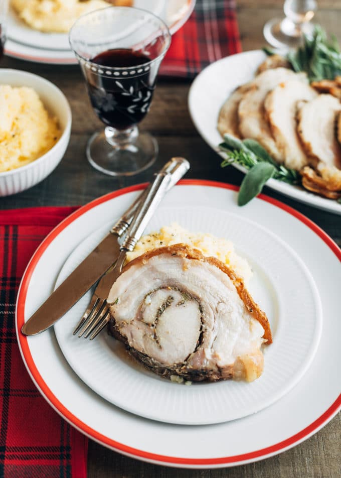 sliced porchetta on a plate with polenta