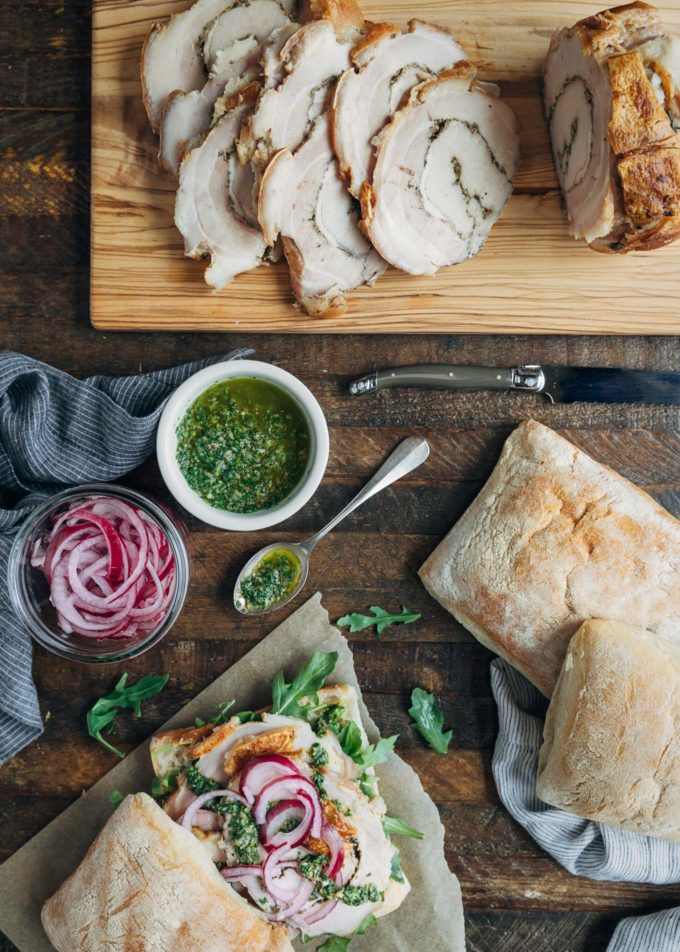 ingredients to make italian porchetta sandwiches on a wood board