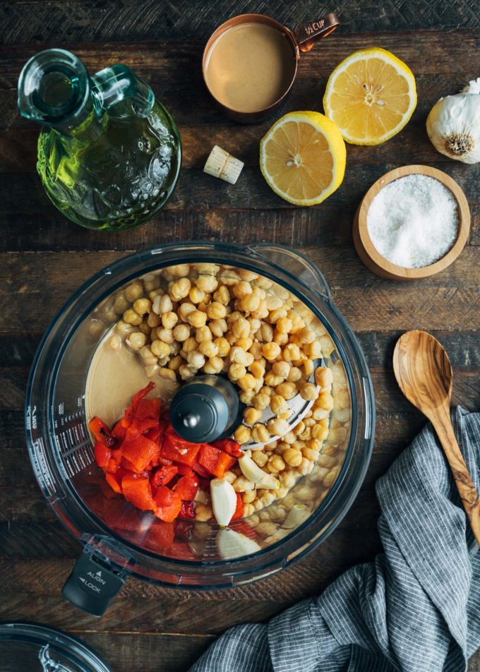 chickpeas, roasted peppers, tahini, and garlic in a food processor bowl for hummus