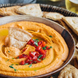 roasted red pepper hummus in a serving bowl with pita chips