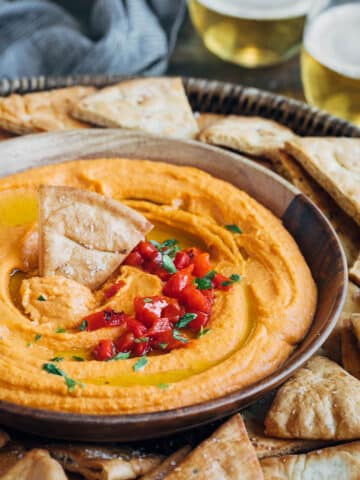 roasted red pepper hummus in a serving bowl with pita chips