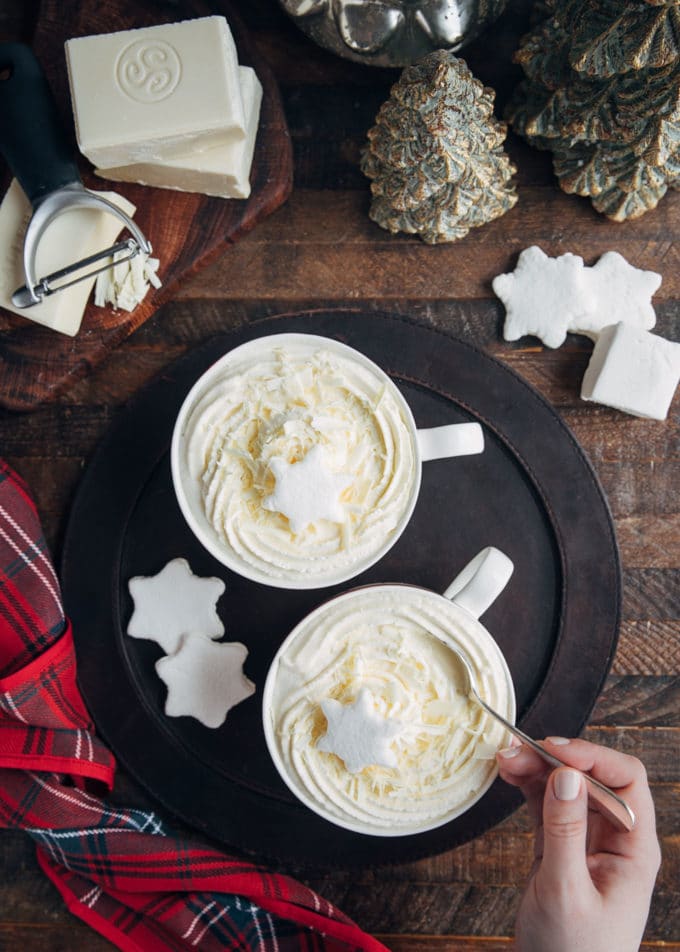 overhead view of mugs of white hot chocolate with whipped cream