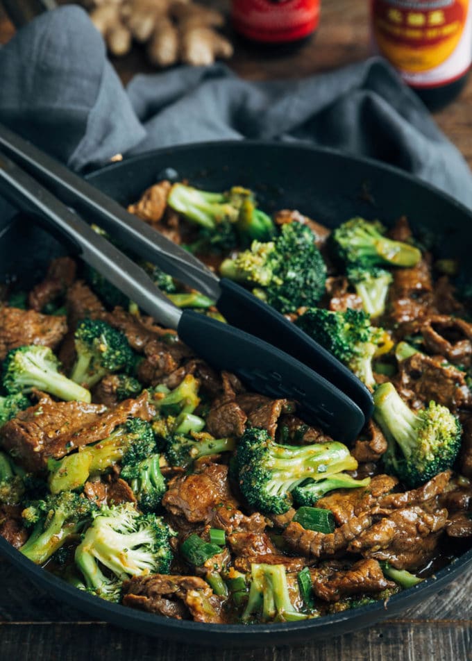 Beef and Broccoli stir-fry in a skillet with tongs