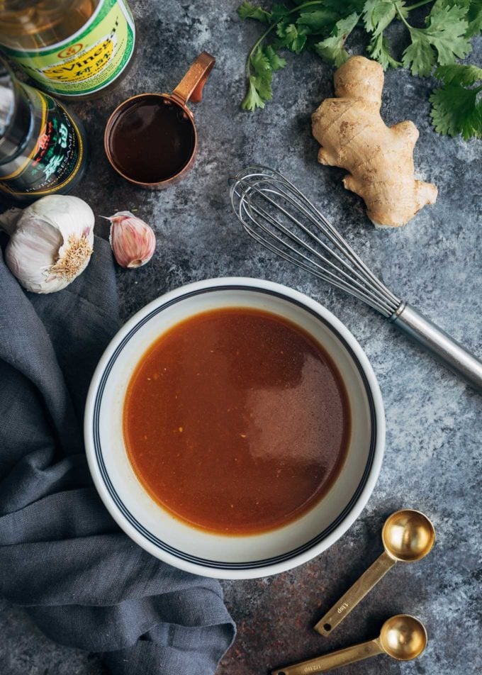 ginger plum salad dressing in a bowl, surrounded by ingredients