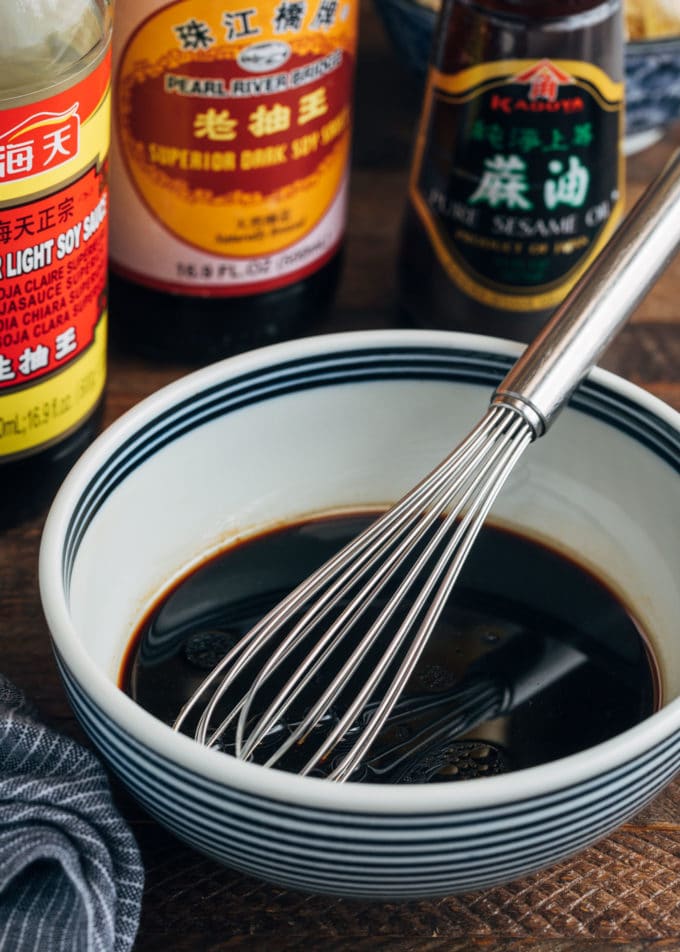 sauce for shrimp lo mein in a bowl with a whisk