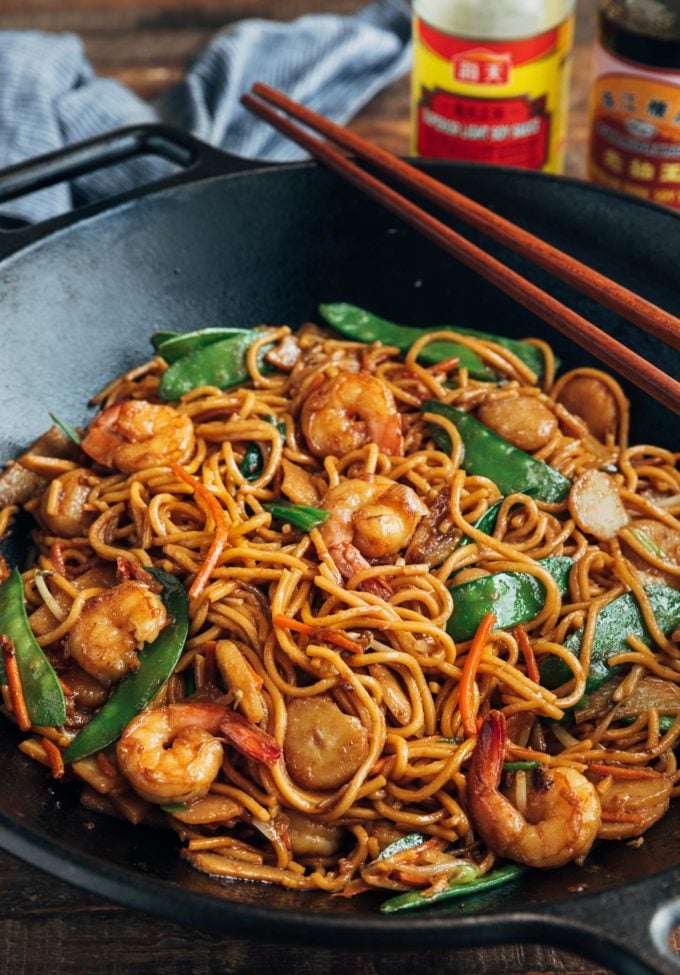 shrimp lo mein cooked in a wok with snow peas and carrots