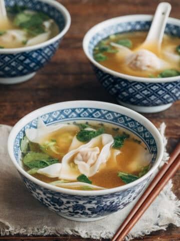 wonton soup in blue floral printed bowls with wooden chopsticks