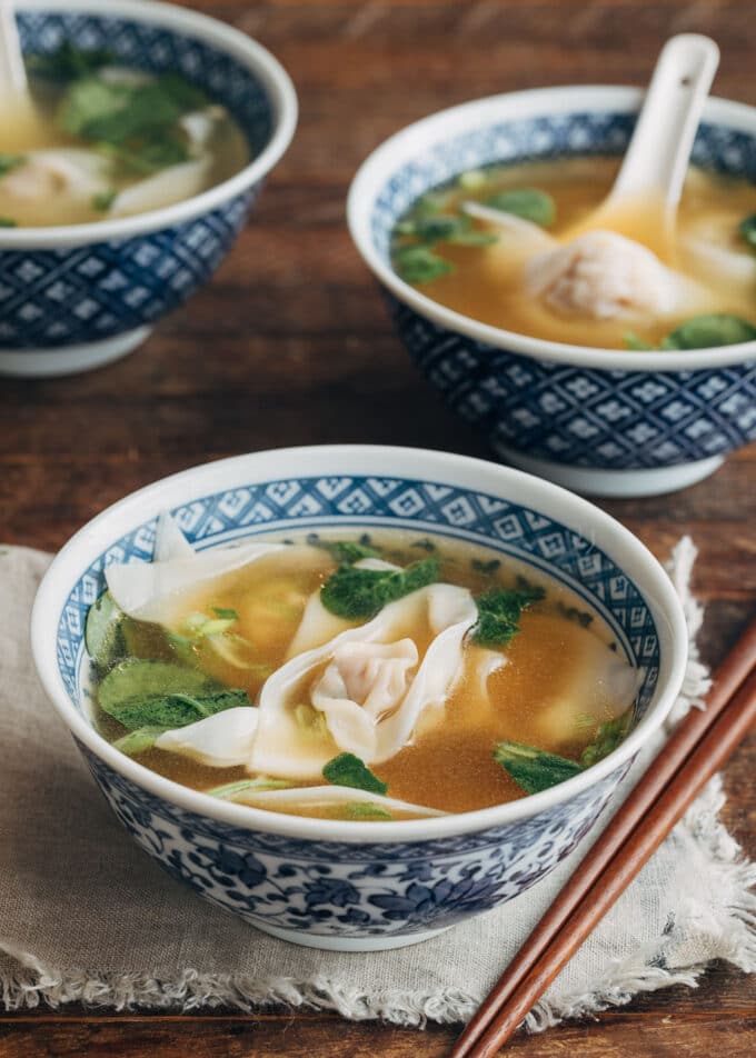 wonton soup in blue floral printed bowls with wooden chopsticks