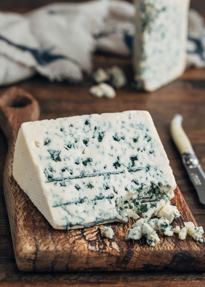 wedge of Danish blue cheese on a wood board