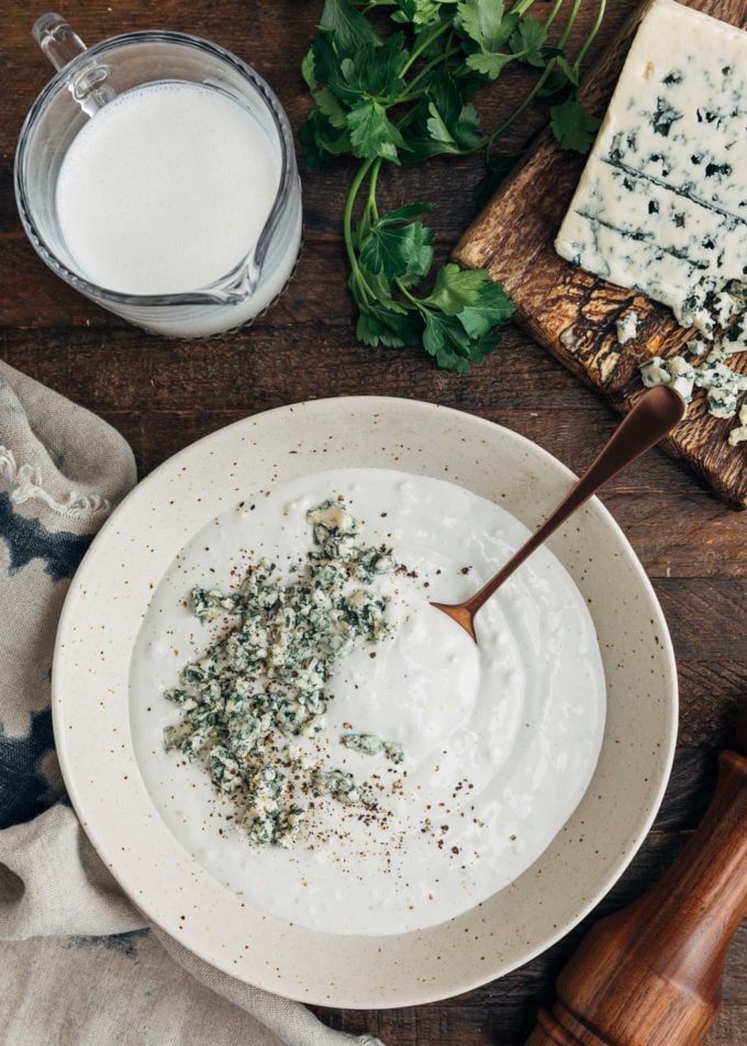 crumbled blue cheese on top of a bowl of blue cheese dressing