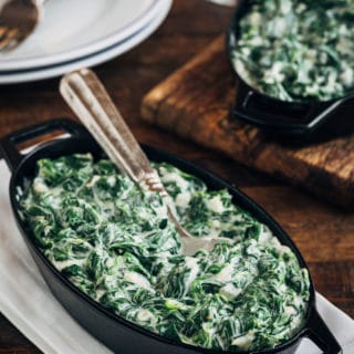 creamed spinach in a cast iron gratin with a spoon