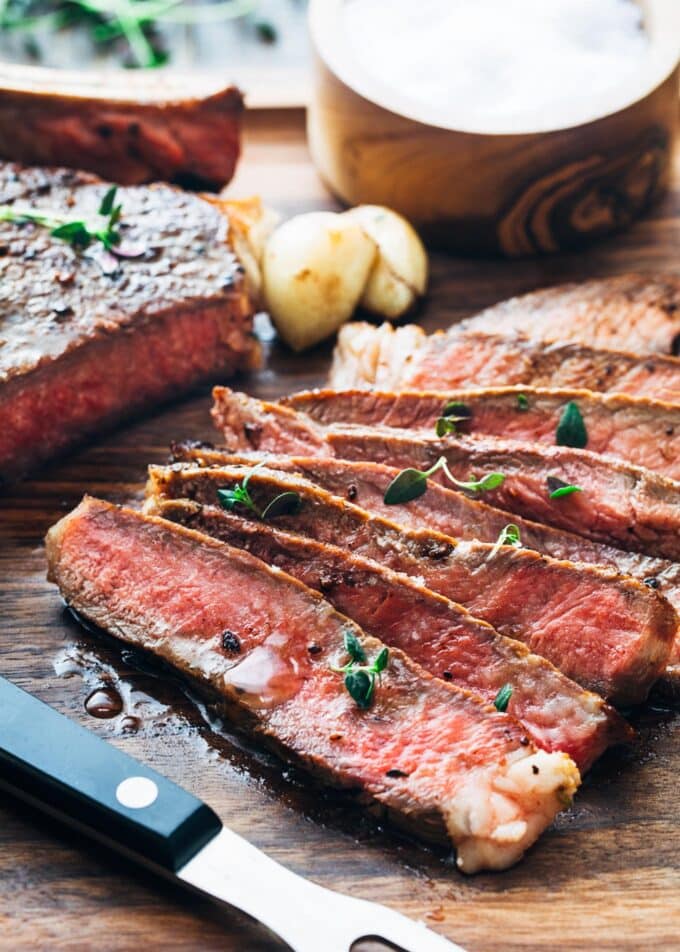 slices of pan seared ribeye steak on a cutting board