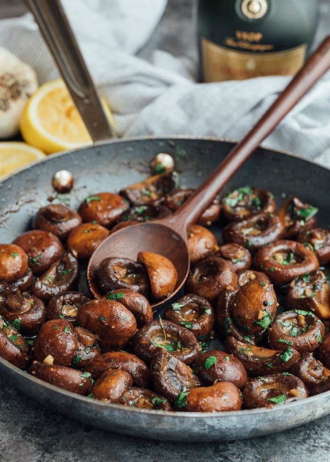 sauteed mushrooms in a skillet with parsley