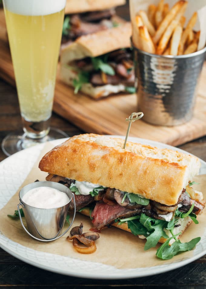 steak sandwich served with horseradish mayo, french fries, and beer