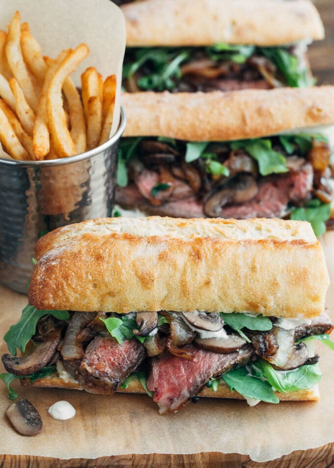 steak sandwiches with horseradish mayo on a wood board