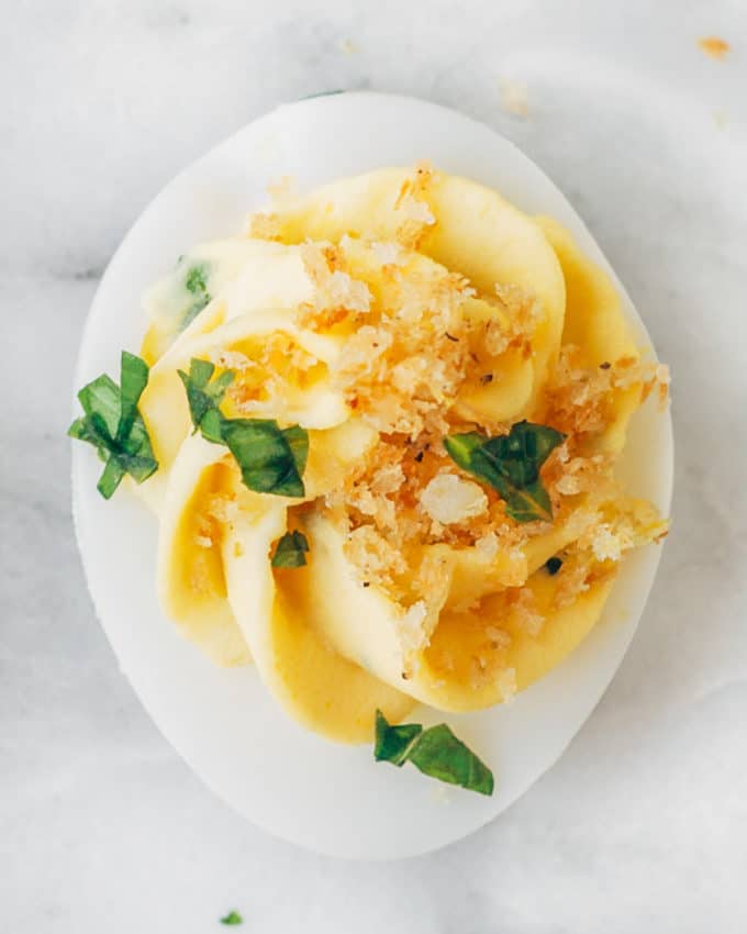 closeup of an Italian deviled egg with panko breadcrumbs and basil