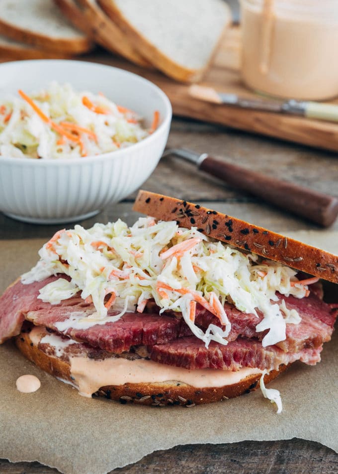 assembly of a corned beef sandwich with coleslaw