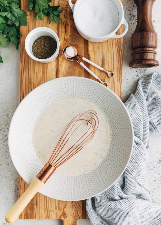 coleslaw dressing in a bowl with a whisk