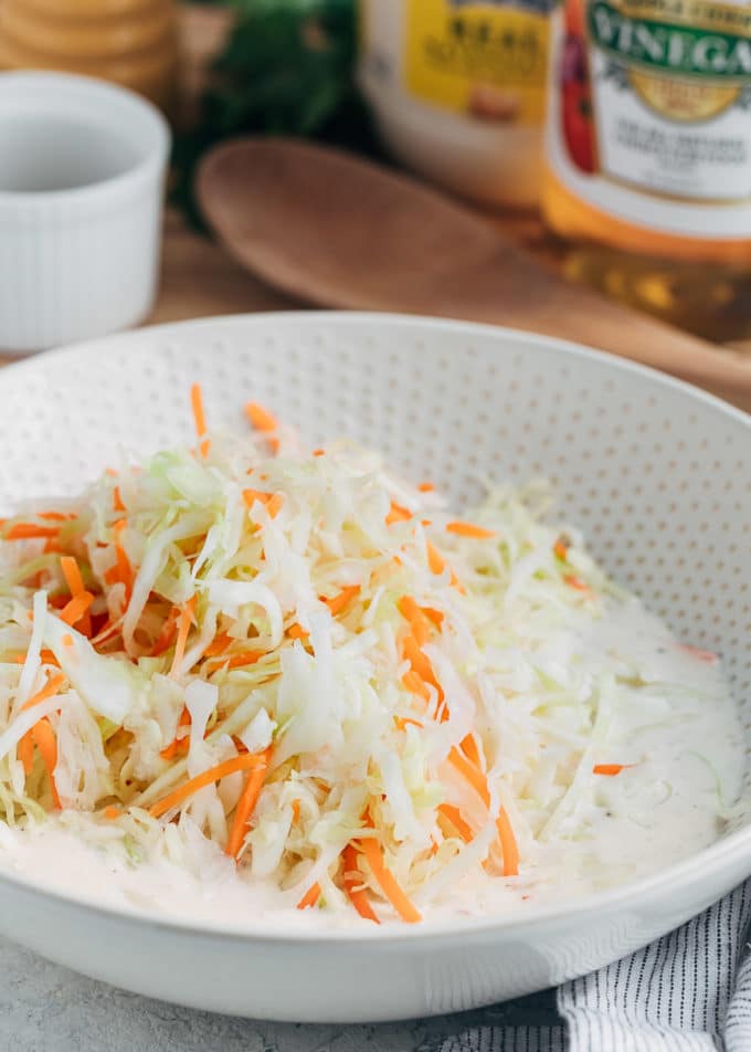 shredded cabbage and carrots in coleslaw dressing in a bowl