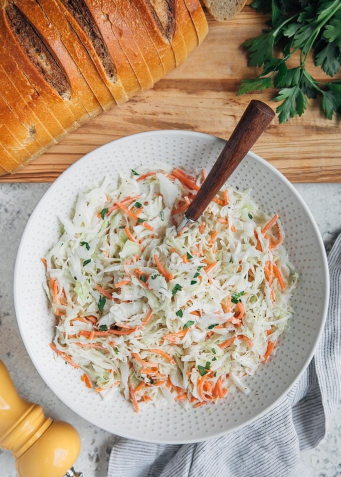 tossed deli-style cole slaw in a bowl with rye bread on the side