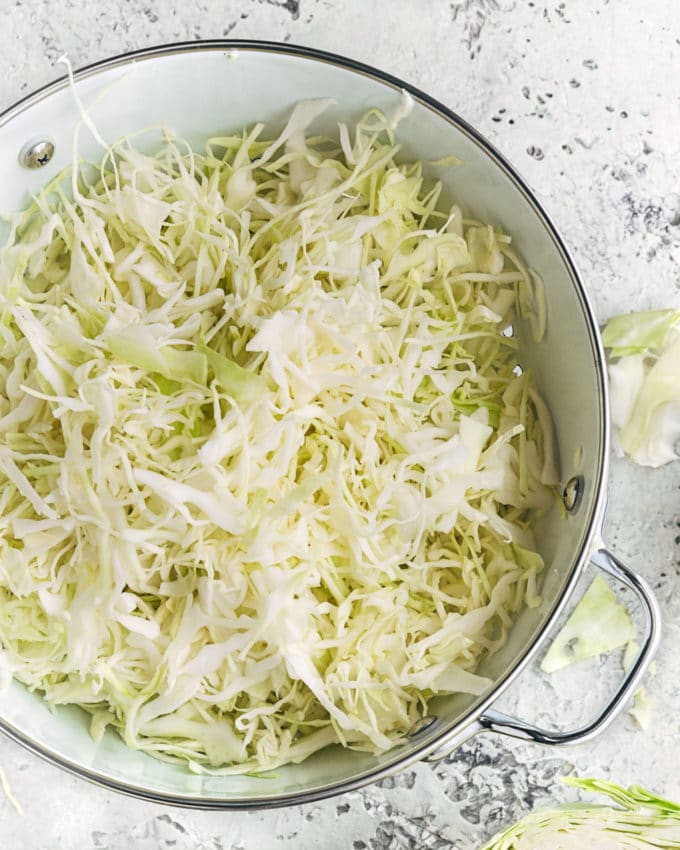 shredded green cabbage in a colander