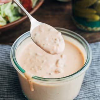 spoonful of an easy homemade Russian dressing recipe over a glass storage jar