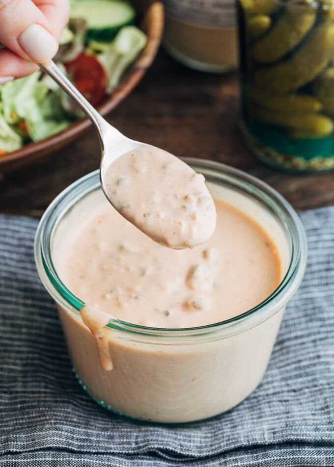 spoonful of homemade Russian dressing with a glass storage jar