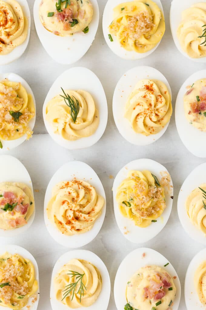 overhead view of garnished deviled eggs on a white board