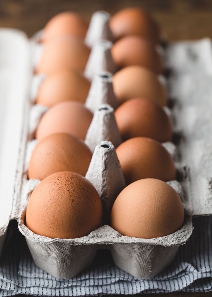 a dozen brown eggs in a carton