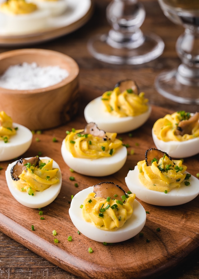 truffled deviled eggs with chives on a wood board