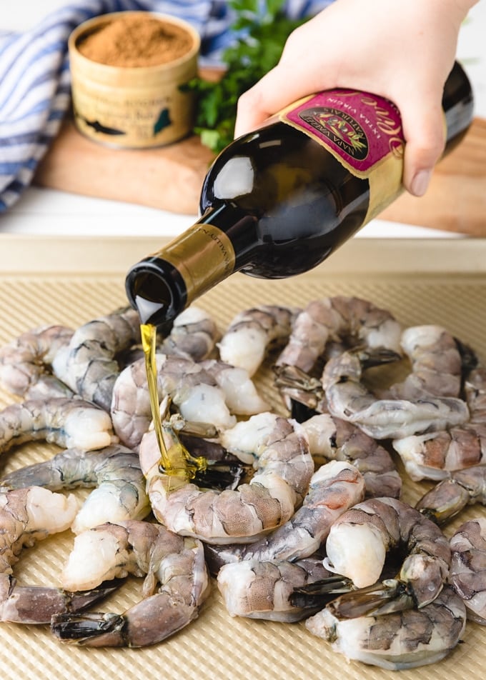 {sponsored} a bottle of Napa Valley Naturals by Stonewall Kitchen extra virgin olive oil pouring over raw shrimp