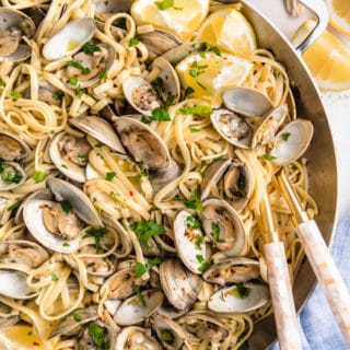 overhead of linguine with clams in a stainless steel pan