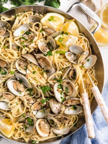 overhead of linguine with clams in a stainless steel pan