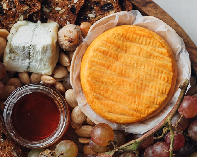 round of epoisses on a cheese board with fruit