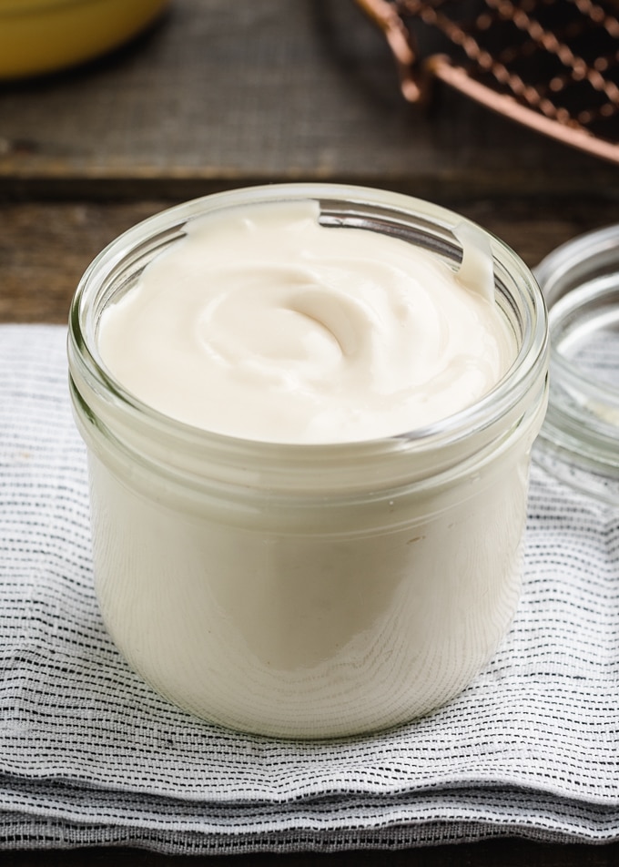 cream cheese glaze in a glass weck jar on a blue and white folded napkin