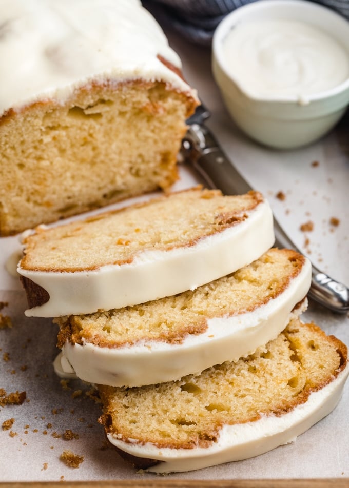 slices of glazed peach loaf cake on a parchment-lined tray