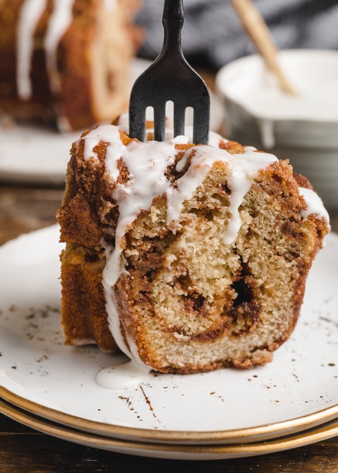 slice of cinnamon swirl coffee cake on a white plate with a black fork