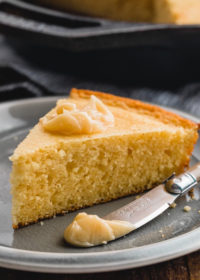 slice of sour cream cornbread on a plate with a dollop of maple butter