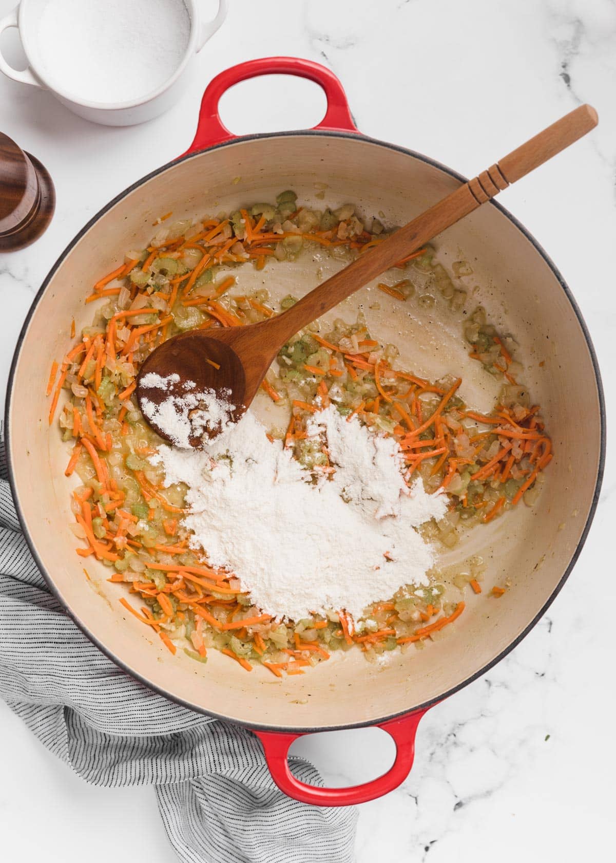 all-purpose flour added to a Dutch oven of sauteed mirepoix with a wooden spoon