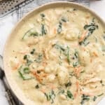 overhead of bowl of rotisserie chicken gnocchi soup on a striped napkin