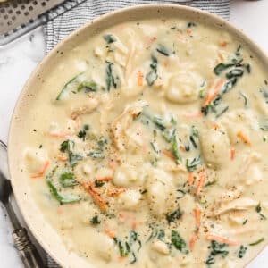 overhead of bowl of rotisserie chicken gnocchi soup on a striped napkin