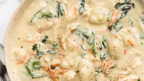 overhead of bowl of rotisserie chicken gnocchi soup on a striped napkin