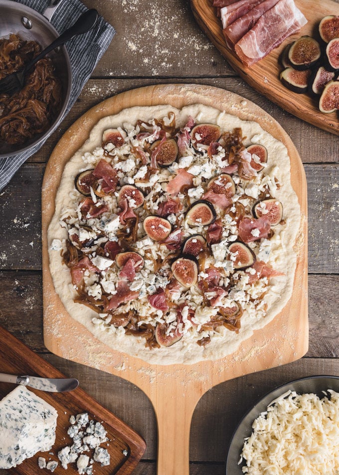 unbaked fig pizza on a wood paddle