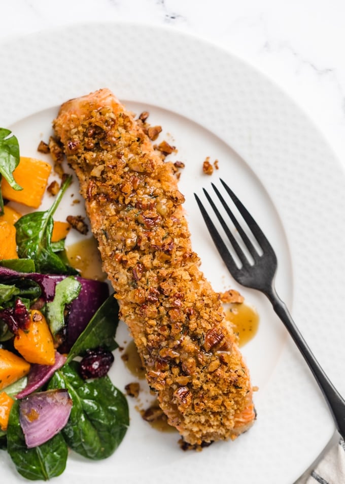 overhead view of pecan crusted salmon plated on a French white plate