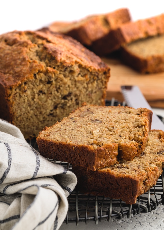 slices of sour cream banana bread on on a black wire cooling rack