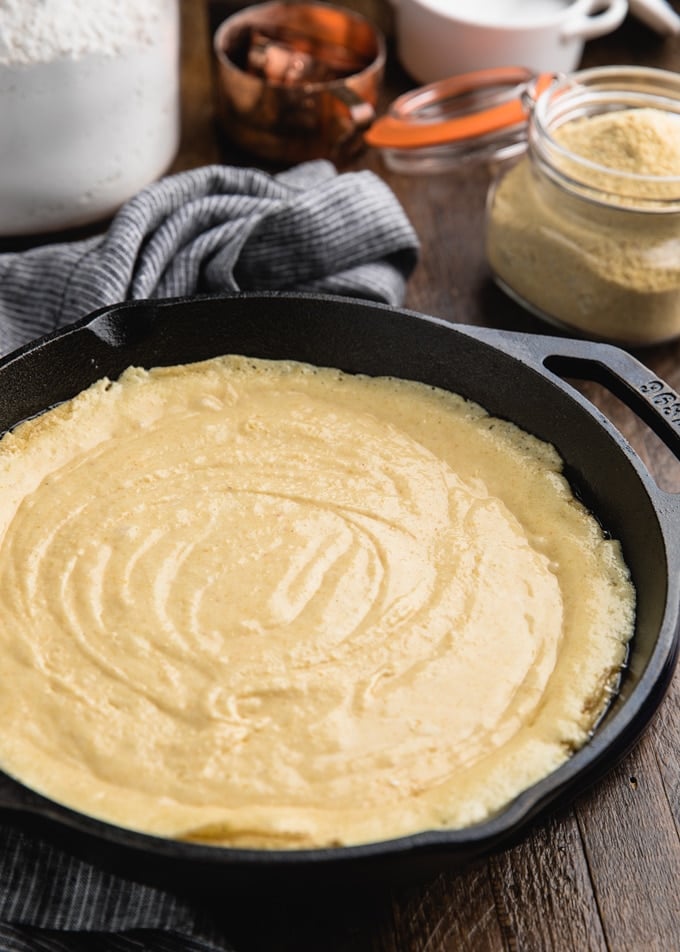 unbaked cornbread batter in a round lodge skillet