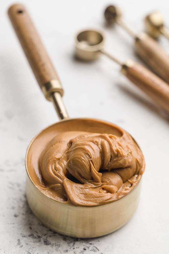 measuring cup filled with Skippy's creamy peanut butter