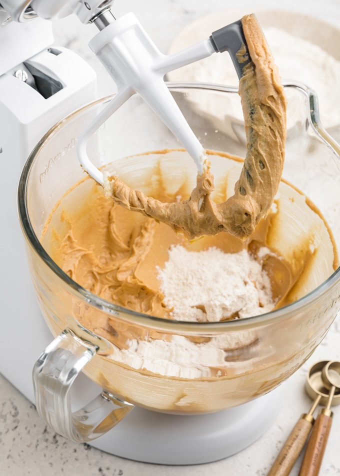 mixing peanut butter blossom cookie dough in a white KitchenAid stand mixer